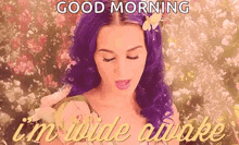 a woman with purple hair and a flower in her hair is saying `` good morning , i 'm wide awake '' .