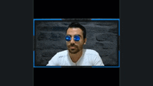 a man with a beard wearing sunglasses and earbuds