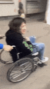 a person in a wheelchair is being pushed by another person .
