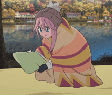 a girl wrapped in a colorful blanket holds a pillow