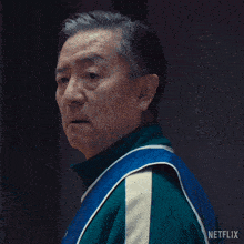 a man wearing a blue and green jacket with netflix written on it
