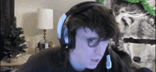 a man wearing headphones is sitting in front of a computer screen .