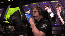 a man wearing headphones sitting in front of a screen that says miniboo