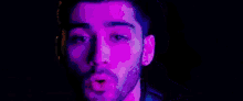 a blurry picture of a man 's face with purple and blue lights coming out of it .