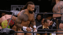 a man in a wrestling ring with a sign that says all elite wrestling on it