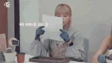 a woman holding a piece of paper with a twice logo in the corner