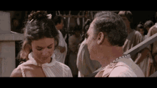 a woman in a white dress stands next to a man in a white shirt