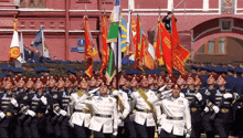 a group of soldiers march in front of a building with a sign that says 1 on it