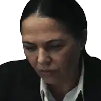 a woman in a suit and tie is looking down with her eyes closed