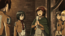 a group of anime characters are standing in front of a brick wall and one of them has the letter a on her back