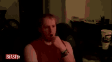 a man covering his face in a dark room with beast tv written on the bottom