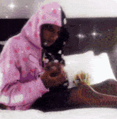 a person wearing a pink hoodie with hearts on it