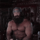 a shirtless man with a beard is sitting in a chair with his hands outstretched