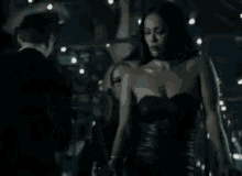 a couple of women hugging each other in a dark room .