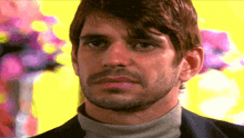 a man with a beard is wearing a turtleneck and looking at the camera