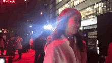 a woman stands on a red carpet in front of a sign that says ' elle '