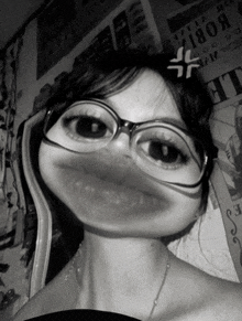 a black and white photo of a woman wearing glasses with a cross on her head