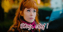 a woman with red hair is wearing a scarf that says okay chef