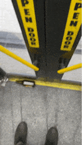 a person 's feet are visible in front of a door that says open door