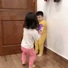 a boy and a girl are standing next to each other in a room .