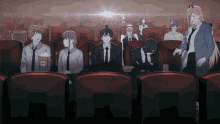 a group of people are sitting in a theater watching a movie and eating popcorn