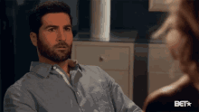 a man with a beard is sitting in front of a woman and the bet logo is visible