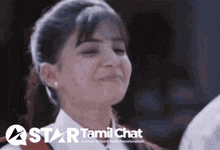 a girl is smiling in front of a star tamil chat banner
