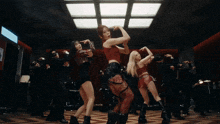 a woman in a red top is dancing with other women