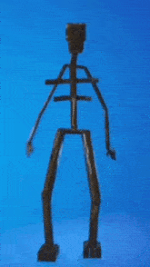 a wooden skeleton is standing on a blue surface .