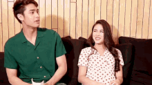 a man and a woman are sitting on a couch .