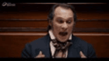 a man in a suit and tie is giving a speech in a courtroom .