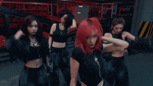 a group of women with red hair are dancing in a dark room