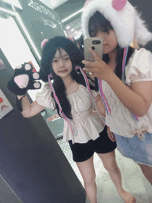 two girls are taking a selfie in front of a sign that says " drama "