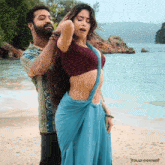 a man and a woman are standing on a beach with the words tolly corner on the bottom