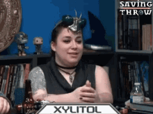 a woman is sitting at a table with a box that says xylitol on it