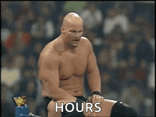 a man without a shirt is sitting in a ring with the words `` hours '' written on the screen .