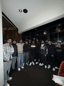 a group of young men are posing for a picture with one wearing a sweatshirt that says " ape "
