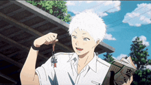 a boy with white hair is holding a book and a keychain