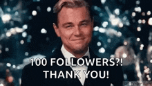 a man in a suit and tie is smiling and saying `` 100 followers ? thank you '' .