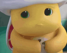a yellow stuffed animal with green eyes and a white hat is looking at the camera .