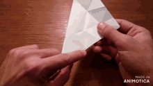 a person is holding a piece of paper and the words made in animotica are on the bottom