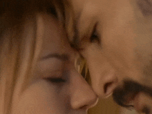 a man with a beard is kissing a woman