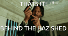 a man holding a gun with the caption that 's it behind the haz shed '