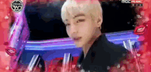 a close up of a man 's face with a mbc logo in the background