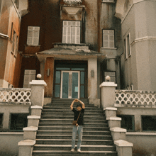 a man stands on a set of stairs in front of a large building