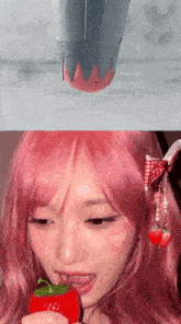 a woman with pink hair holds a strawberry in her mouth