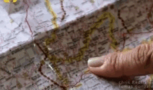 a person pointing at a map with the name chris redfield on the bottom right
