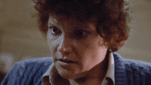 a close up of a woman 's face with a sweater on