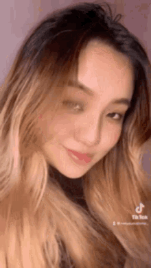 a close up of a woman 's face with a pink background .