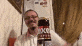 a man is holding a bottle of oxo beer in his hands .